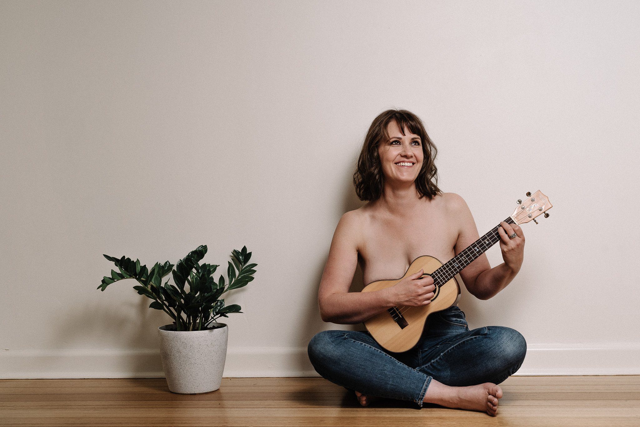 Boudoir photography in Adelaide SA - A lady sitting cross legged with a Ukulele positioned over her naked top half.