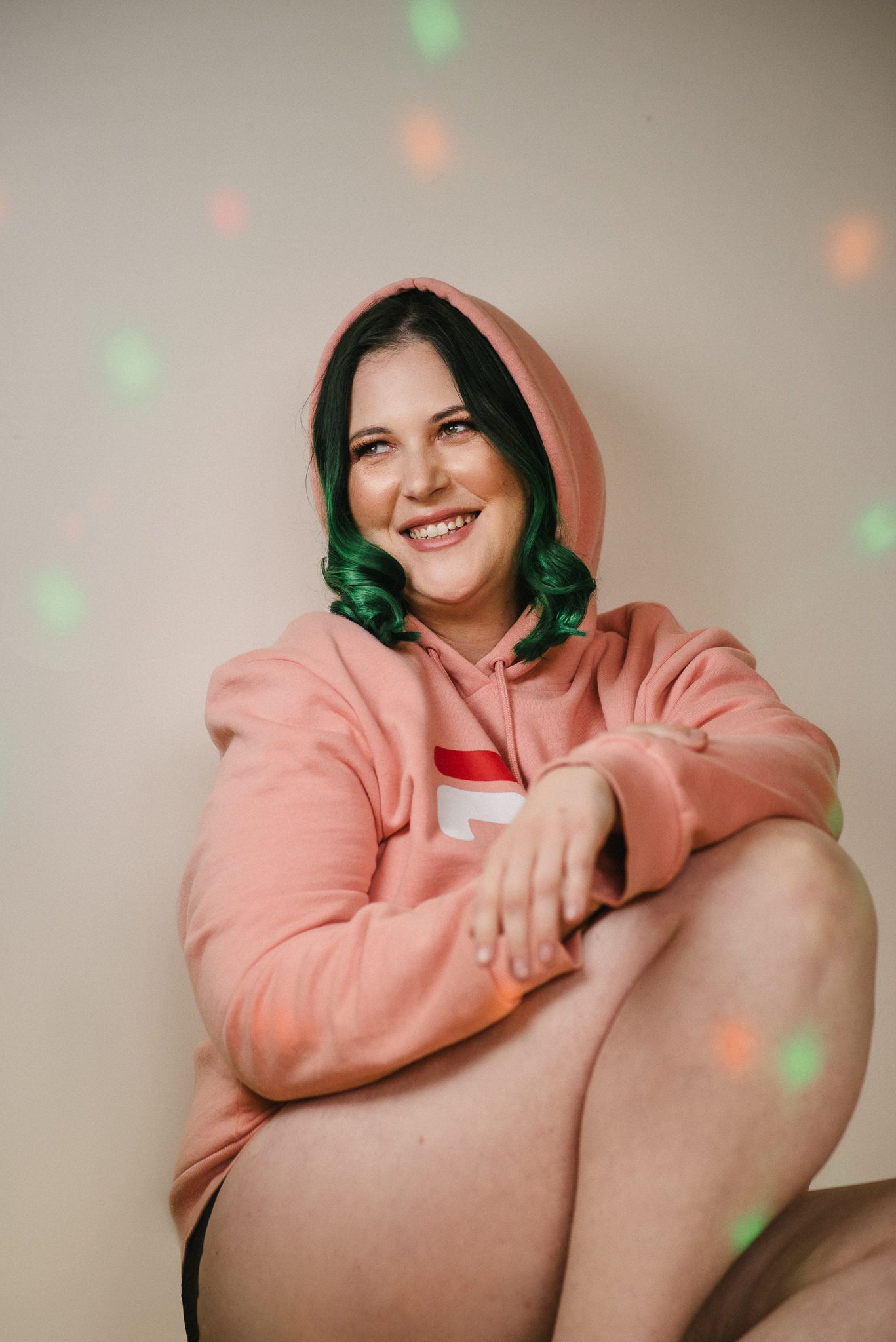 Lady with green hair wearing a hoodie