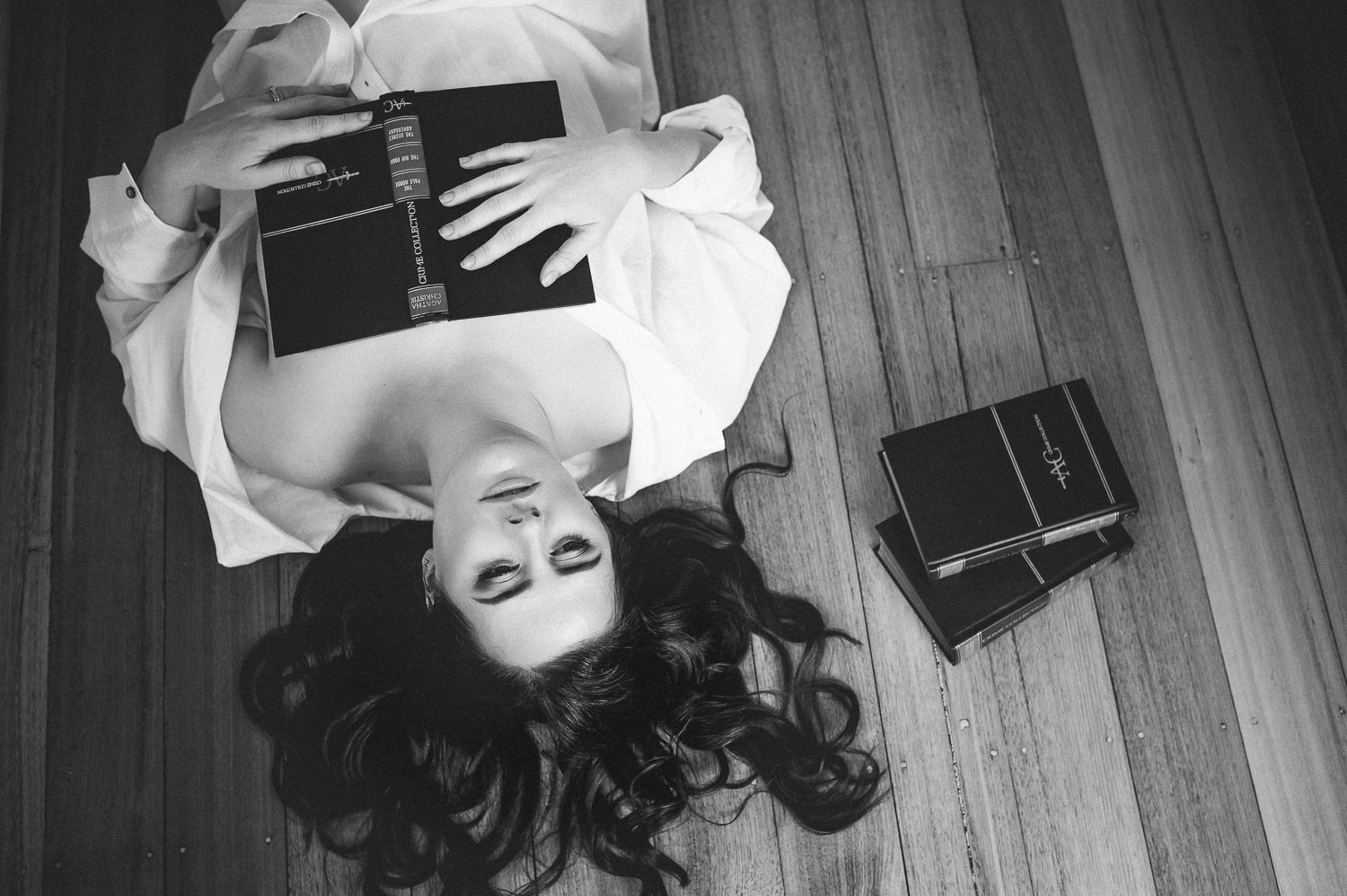 Implied topless photography using books.
