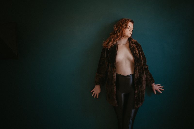 Implied topless photography with an open jacket.
